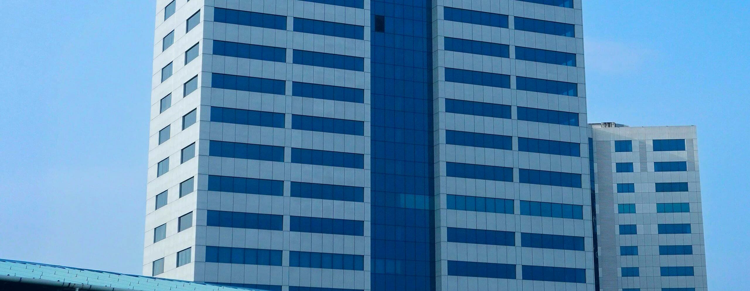 A modern commercial office tower against a clear sky